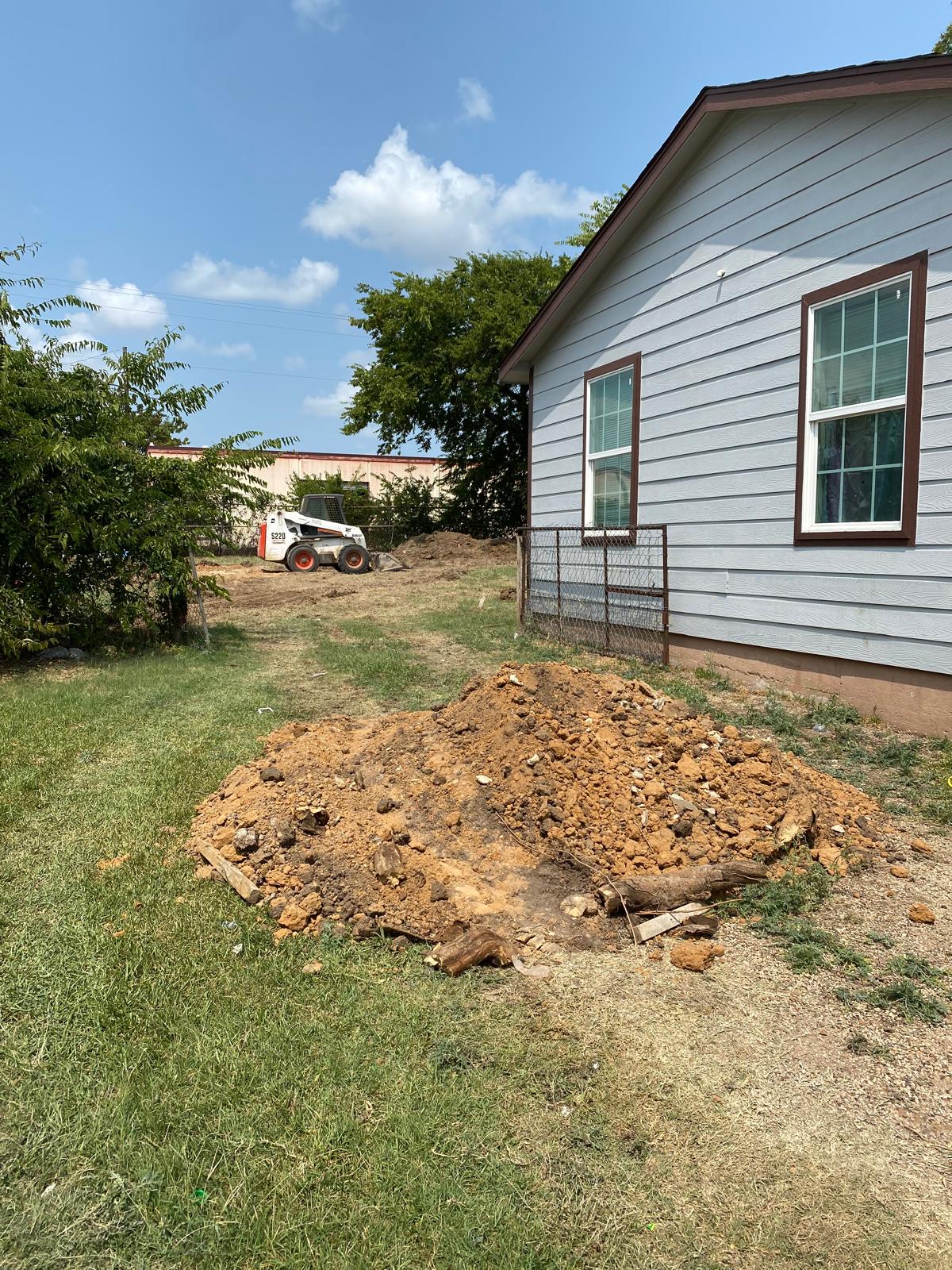 Site grading and excavation work alongside the home